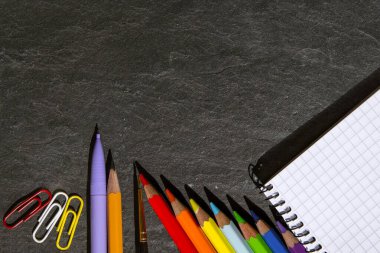 Okula dönelim. Renkli kalemler ve karanlık bir arka plan üzerinde çalışmak için okul konuları. Soyut arkaplan dokusu. Tasarım veya metin eklemek için kavram. Yatay arkaplan. Geçmişi. Kapat.