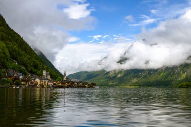 Hallstatt, Avusturya. Hallstattersee Gölü 'ne ve Alpler dağlarına bakın. Göl kıyısında şapeli olan antik evler. Avusturya 'da turizm. Alpler popüler bir turizm merkezidir. Avrupa.