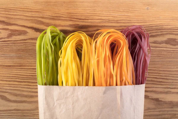 Kolorowe Spaghetti Niegotowane Podłoże Drewniane — Zdjęcie stockowe