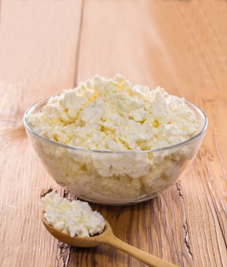 Ahşap arka plan üzerine bir kase süzme peynir