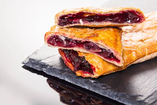 Siyah ve beyaz arka plan üzerinde ekmek, vişne strudel