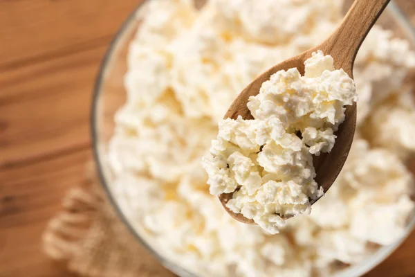 ahşap arka plan üzerine bir kaşık süzme peynir