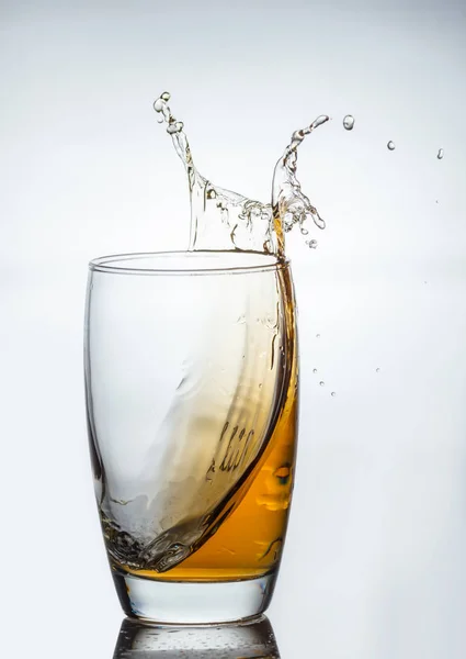 splash of drink from a glass with reflection