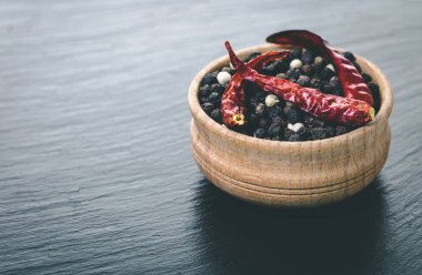 siyah arka plan üzerine bir kase kuru acı biber