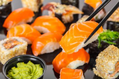 Japon mutfağı, sopa ile somon suşi tutmak.