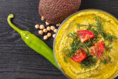 Humus avokado ve acı biber siyah bir zemin üzerine