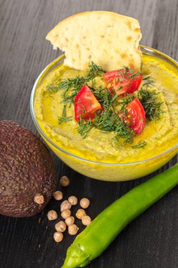Humus avokado ve acı biber siyah bir zemin üzerine