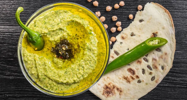 Humus ıspanak ve acı biber siyah ahşap zemin ile