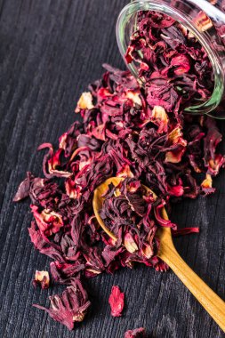 Kuru çay siyah ahşap arka planda kavanozun dışarı dökülür