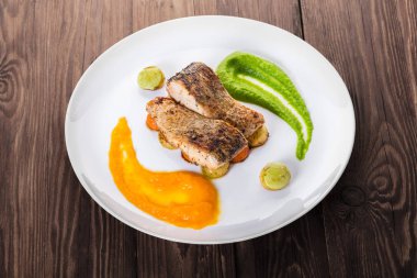 ahşap bir arka planda sebze ile kızarmış balık