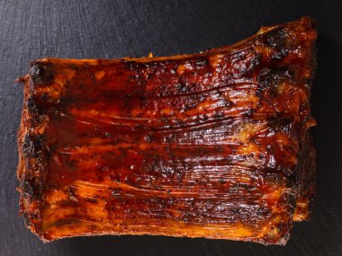 siyah bir arka planda pişmiş domuz kaburga yakın çekim