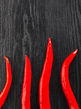 Siyah ahşap arka planda sıcak Chili Pepper