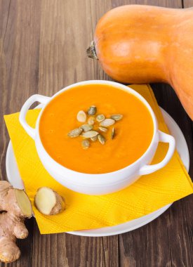 ahşap bir arka planda zencefil ile kabak krem çorbası