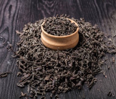 Siyah ahşap arka planda kuru büyük yaprak çay