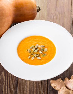 ahşap bir arka planda zencefil ile kabak krem çorbası