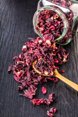 Kuru çay siyah ahşap arka planda kavanozun dışarı dökülür