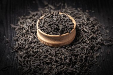 Siyah ahşap arka planda kuru büyük yaprak çay