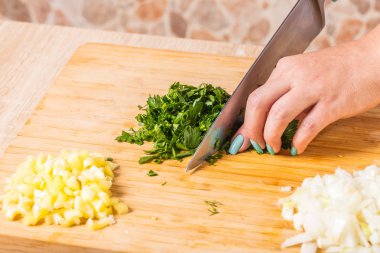 Ahşap tahta üzerinde bir bıçakla Yeşiller Cook keser