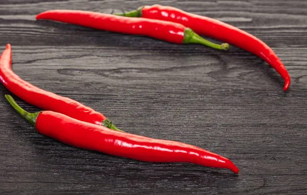 Hot Chili Pepper Een Zwarte Houten Achtergrond — Stockfoto