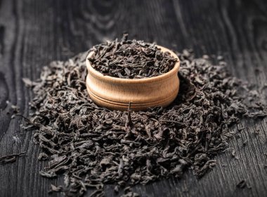 Siyah ahşap arka planda kuru büyük yaprak çay