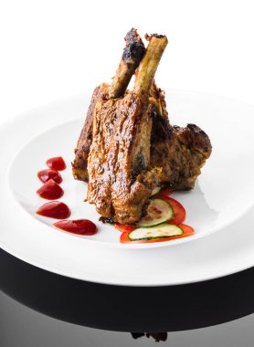 beyaz bir arka plan üzerinde sos ve sebze ile kızarmış kaburga