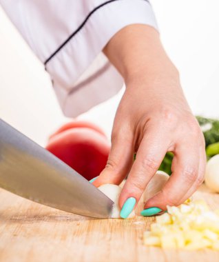 Cook ahşap tahta üzerinde bir bıçak ile soğan keser