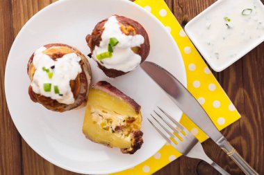 Ahşap bir arka planda peynir ve pastırma ile pişmiş patates