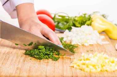 Ahşap tahta üzerinde bir bıçakla Yeşiller Cook keser