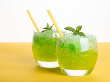 Sarı bir arka planda buzdan kokteyl alkollü Mojito