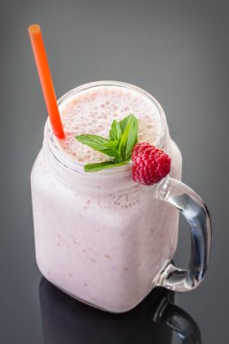 Siyah arka plan üzerinde bir saman ile kavanozda Milkshake meyve