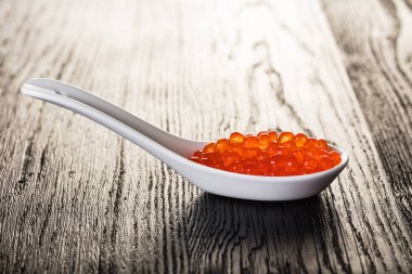 tahta arka plan üzerinde kaşık kırmızı havyar