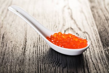 ahşap arka plan üzerinde bir kaşık kırmızı havyar