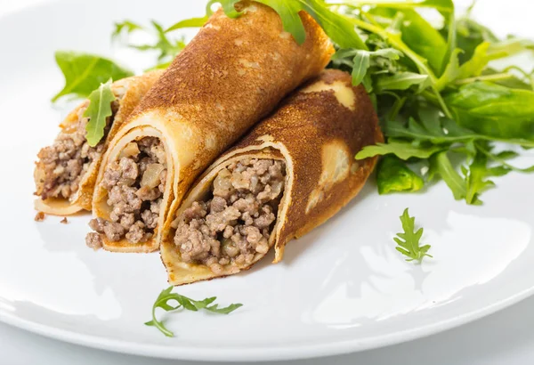 Beyaz arka planda et doldurma ve salata ile krep