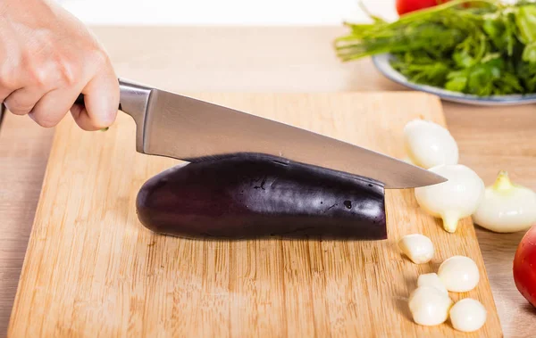 Cozinheiro Corta Berinjela Com Uma Faca — Fotografia de Stock