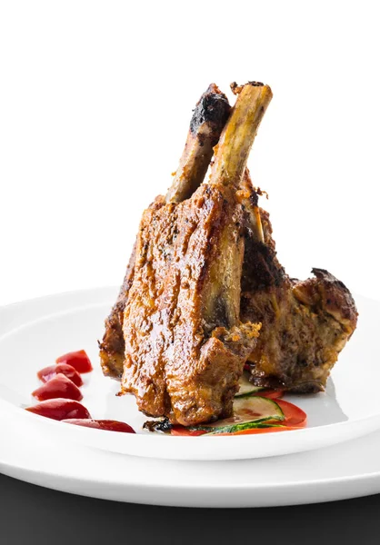 beyaz bir arka plan üzerinde sos ve sebze ile kızarmış kaburga