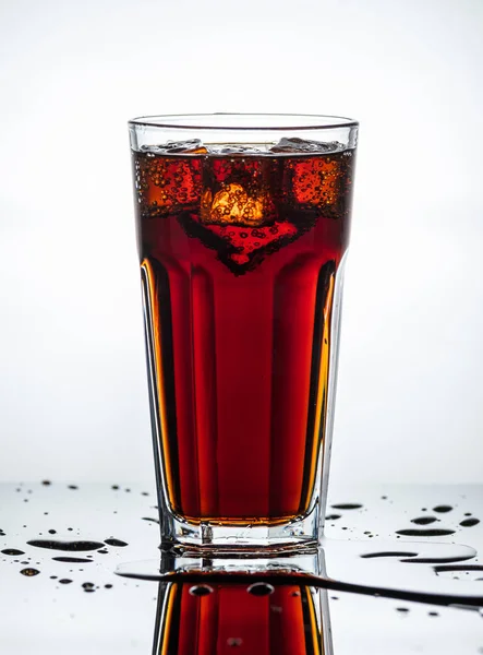 Splashes of drink from a glass with ice cubes