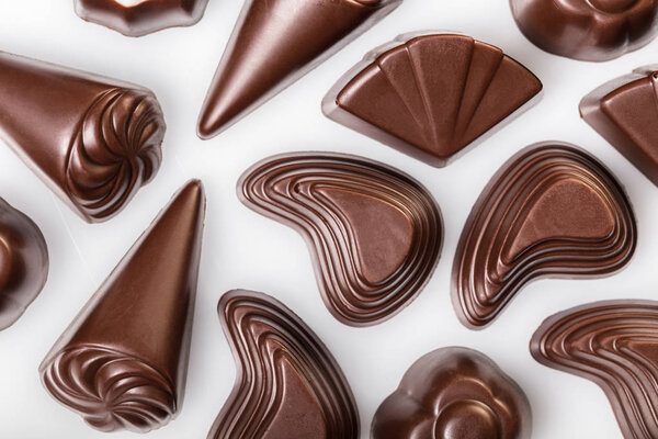 food background of assorted chocolates on white