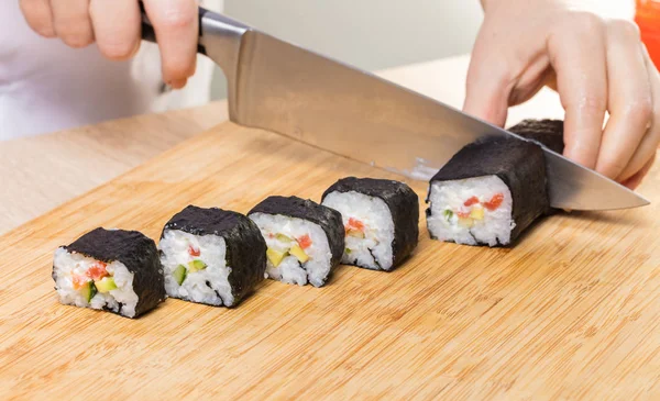 Japon mutfağı. Şef ruloları keser, eller yakın çekim