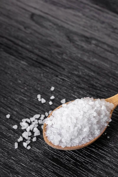 Siyah ahşap zemin üzerine bir kaşık tuz