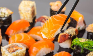 Japon mutfağı, sopa ile somon suşi tutmak.