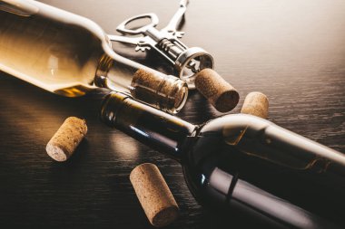 Ahşap arka planda şarap ve tirbuşon şişeleri