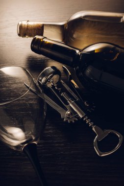 Ahşap arka planda şarap ve tirbuşon şişeleri