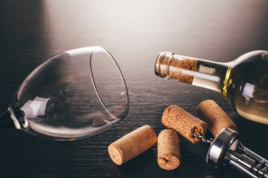 Ahşap arka planda bir şişe şarap ve tirbuşon.