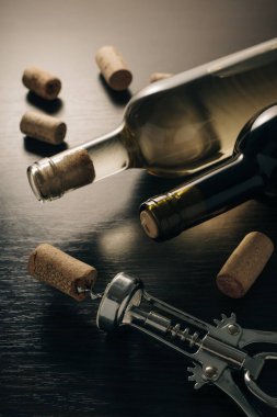 Ahşap arka planda şarap ve tirbuşon şişeleri