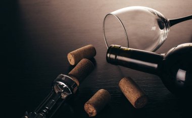 Ahşap arka planda bir şişe şarap ve tirbuşon.