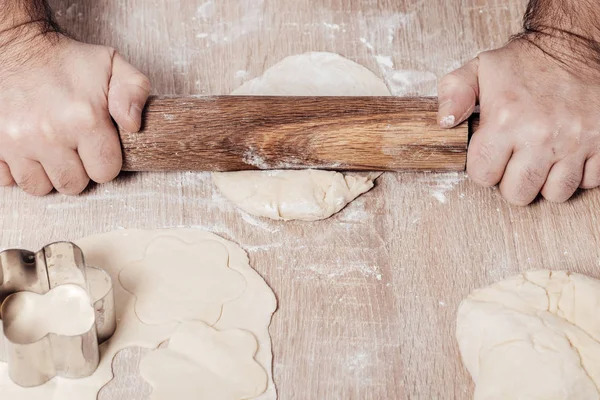 Male cook rolls out dough with rolling pin — Stock Photo, Image