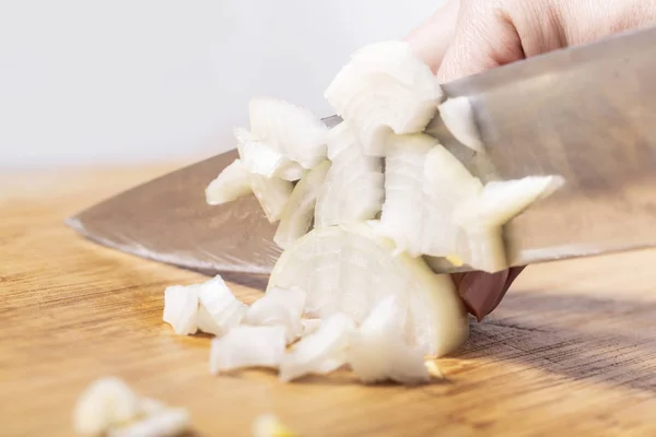 stock image cook cuts onion on a wooden board