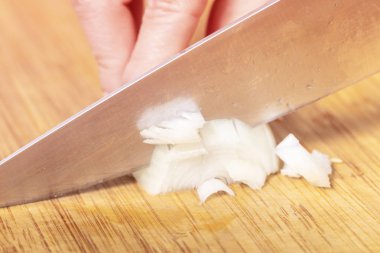 aşçı ahşap bir tahta üzerinde soğan keser