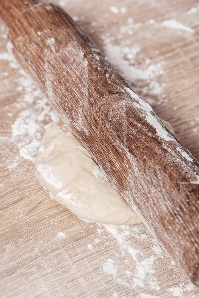 Dough and wooden rolling pin close-up — Stock Photo, Image