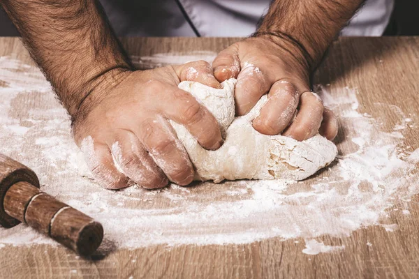 Male chef kneads the dough — Stock Photo, Image